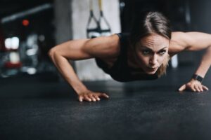 woman doing push ups at the gym