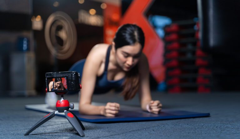 Woman filming herself at the gym to check for form and track progress.