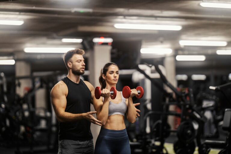 A personal trainer working with a woman in the gym.